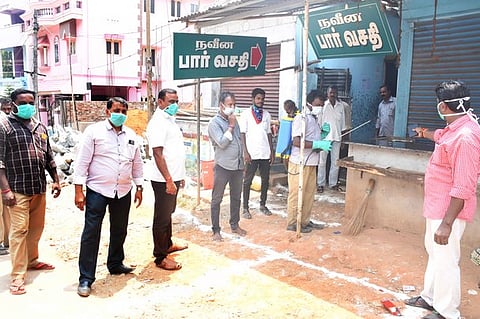 மதுக்கடையில் கிருமி நாசினி தெளிக்கும் பணியை ஆய்வு செய்த அதிகாரிகள்.