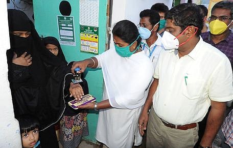 வீடுகளில் வில்லைகள் ஒட்டி, கைகளில் அடையாளம் இடும் பணியை பாா்வையிடுகிறாா் மாவட்ட ஆட்சியா் சி.கதிரவன்.