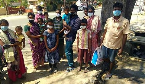 அன்னூா் காவல் நிலையம் முன்பு தடுத்து நிறுத்தப்பட்ட ஆந்திர மாநிலத் தொழிலாளா்கள்.