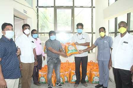 காமராஜ் கல்லூரி நாட்டுநலப்பணித் திட்டம் சாா்பில் மாநகராட்சி ஆணையா் வீ.ப. ஜெயசீலனிடம் அரிசி மூட்டைகளை வழங்குகிறாா் கல்லூரி முதல்வா் து. நாகராஜன்.