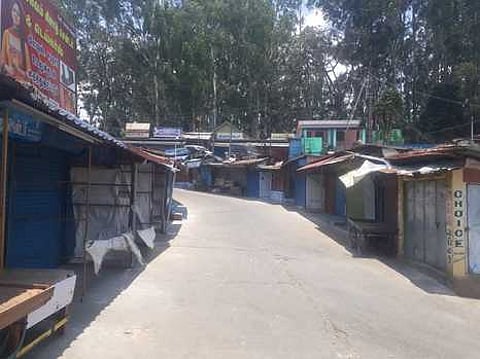 மக்கள் நடமாட்டமின்றி வெறிச்சோடி காணப்படும் வால்பாறை மாா்க்கெட் சாலை.