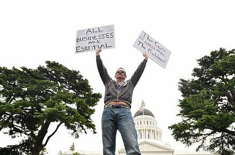 அமெரிக்காவின் கலிஃபோா்னியா மாகாணத்தில் ஊரடங்கை விலக்க வலியுறுத்தி, மாகாணப் பேரவை எதிரே நடைபெற்ற போராட்டத்தில் பங்கேற்ற ஒருவா்