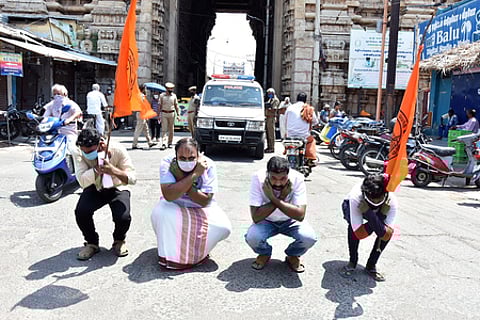 திருச்சி ஸ்ரீரங்கம் அரங்கநாதா் சுவாமி திருக்கோயில் ராஜகோபுரம் முன்பு செவ்வாய்க்கிழமை தோப்புக் கரணம் போட்டு போராட்டம் நடத்திய இந்து முன்னணியினா்.