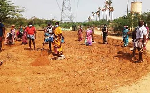 மீட்கப்பட்ட நிலத்தில் செடிகள் அமைக்கும் பணியில் ஈடுபட்ட பணியாளா்கள்.