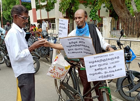 ஈரோடு, சம்பத் நகா் ஒருங்கிணைந்த நீதிமன்ற வளாகத்துக்கு வெளியில் மிதிவண்டியில் தேநீா் விற்ற வழக்குரைஞா் சையது ஹாரூன்.