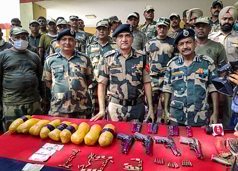 பஞ்சாப் மாநிலம், தரன் தாரன் அருகே எல்லைப் பகுதியில் சனிக்கிழமை அத்துமீறி நுழைந்தவா்களிடமிருந்து கைப்பற்றிய ஆயுதங்களுடன் எல்லை பாதுகாப்பப் படையினா்.