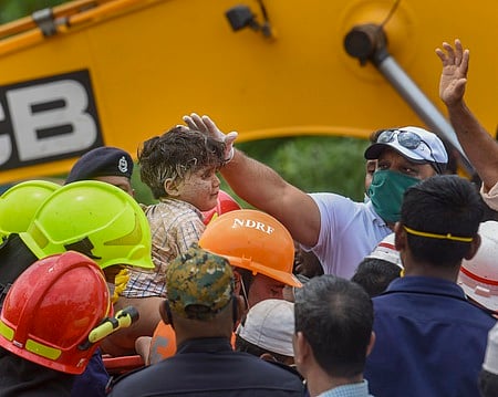 மகாராஷ்டிர மாநிலம், ராய்கட் மாவட்டத்தில் விபத்துக்குள்ளான கட்டட இடிபாடுகளுக்கு இடையிலிருந்து செவ்வாய்க்கிழமை மீட்கப்பட்ட சிறுவன்.