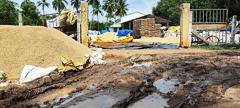 நல்லத்துக்குடி நேரடி நெல் கொள்முதல் நிலையத்தில் மழையில் நனைந்த நெல் மூட்டைகள் மற்றும் சேறும், சகதியுமாக மாறிய பாதை.