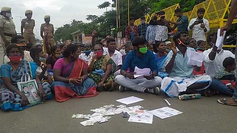 ஆதாா் அட்டைகளை சாலையில் வீசி போராட்டம்