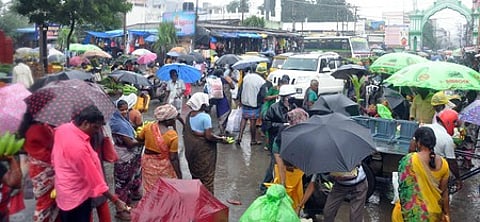 காந்தி சந்தையில் பொருள் வாங்க கொட்டும் மழையிலும் வந்த மக்கள்.