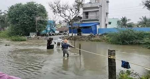 சூச்சனி தரைப்பாலம் புதன்கிழமை தண்ணீரில் மூழ்கியதால் கயிற்றின் உதவியுடன் ஆற்றைக் கடக்கும் பொதுமக்கள்.