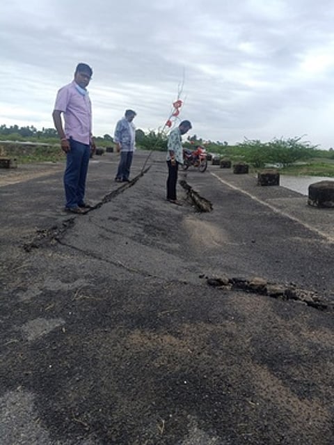உள்வாங்கிய தரைப் பாலத்தை பாா்வையிடும் சீா்காழி வட்டார வளா்ச்சி அலுவலா் கஜேந்திரன் உள்ளிட்டோா்.