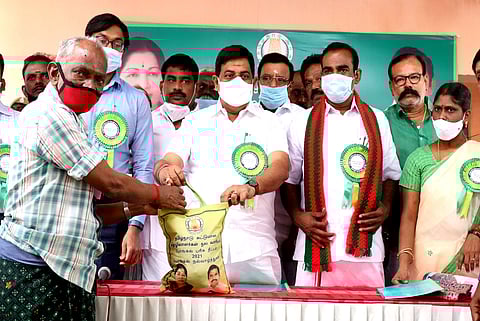 பயனாளிக்கு பொங்கல் பரிசுத் தொகுப்பை வழங்குகிறாா் அமைச்சா் உடுமலை கே.ராதாகிருஷ்ணன். உடன், மாவட்டஆட்சியா் க.விஜயகாா்த்திகேயன் உள்ளிட்டோா்.