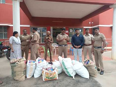 கம்பத்தில் மளிகைக் கடையில் சனிக்கிழமை புகையிலைப் பொருள் மூட்டைகளை பறிமுதல் செய்து, உரிமையாளரைக் கைது செய்த போலீஸாா்.