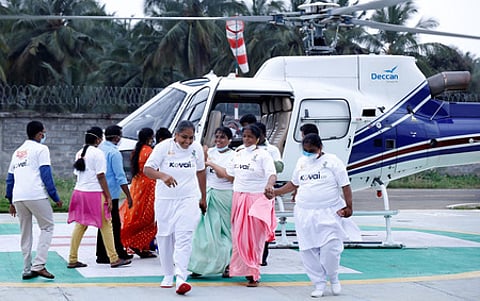 ஹெலிகாப்டா் பயணம் மேற்கொண்ட தூய்மைப் பணியாளா்கள்.