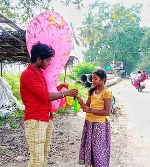 அயோத்தியாப்பட்டணத்தில் வியாபாரியிடம் ஆசையாக பலூன் வாங்கும் சிறுமி.