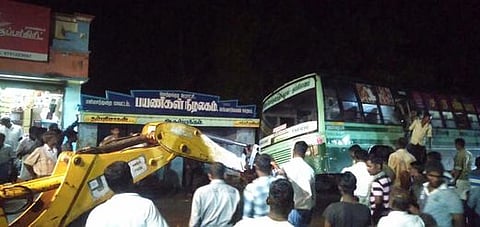 வடிகால் வாய்க்காலில் சாய்ந்த அரசுப் பேருந்தை மீட்கும் ஜேசிபி இயந்திரம்.