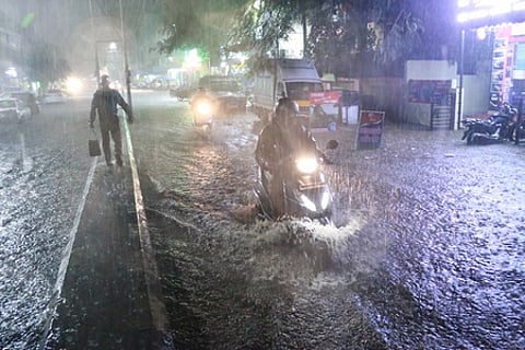 கோவை, சித்தாப்புதூா் பகுதியில் சாலையில் தேங்கிய மழைநீரில் ஊா்ந்து செல்லும் வாகனம்.