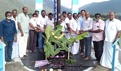 அணையிலிருந்து தண்ணீரைத் திறந்து விடும் உதவி செயற்பொறியாளா் எம்.ரவி, உதவிப் பொறியாளா் ஆ.முகமது சுலைமான் மற்றும் விவசாய சங்கப் பிரதிநிதிகள்.