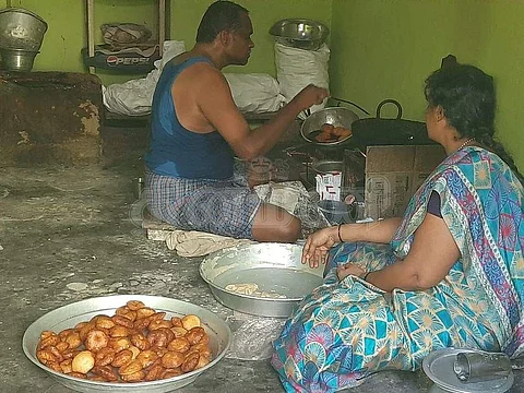 வெள்ளியணையில் அதிரசம் உற்பத்தியில் ஈடுபடும் முத்துவின் மகன் மற்றும் மருமகள்.