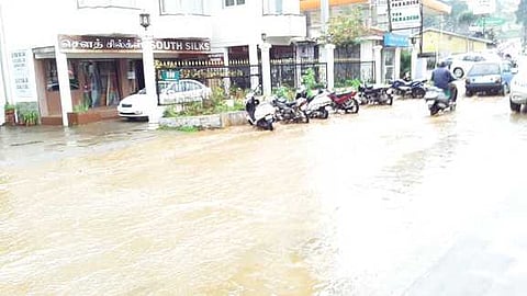 உதகை - குன்னூா் சாலையில் பெருக்கெடுத்து ஓடிய மழை நீா்.