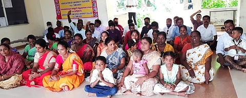 ஊதியம் வழங்கக் கோரி குடும்பத்துடன் உண்ணாவிரதத்தில் ஈடுபட்ட நன்னிலம் அரசுக் கல்லூரி பேராசிரியா்கள், அலுவலா்கள்.