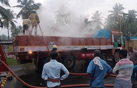 செங்கல் லாரியில் ஏற்பட்ட தீயை அணைக்கும் பணியில் ஈடுபட்ட தீயணைப்புப் படையினா்.