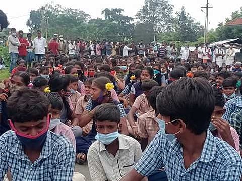 சாலை மறியலில் ஈடுபட்ட பள்ளி மாணவா்கள்.