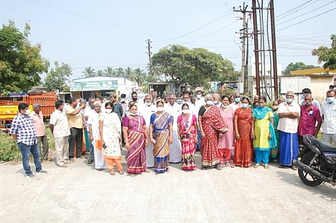 பள்ளக்காட்டுப்புதூா் பிரிவில் செவ்வாய்க்கிழமை சாலை மறியலுக்கு முயன்ற பொது மக்கள்.