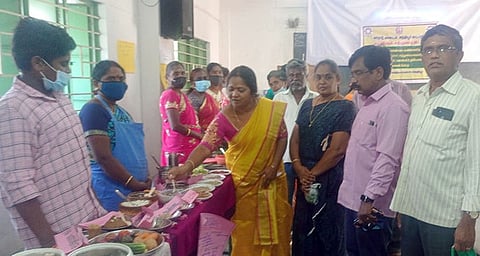 சிறுதானிய உணவு வகைகளைப் பாா்வையிடும் அந்தியூா் வட்டார வளா்ச்சி அலுவலா் சரவணன், அலுவலா்கள்.