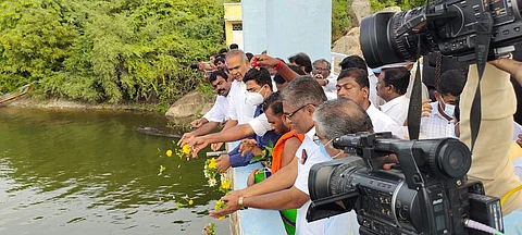 மணிமுத்தாறு அணையில் தண்ணீர் திறந்து வைத்து பூ தூவுகிறார் சட்டப்பேரவைத் தலைவர் அப்பாவு. உடன் மாவட்ட ஆட்சியர் விஷ்ணு உள்ளிட்டோர் உள்ளனர்.
