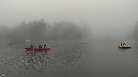 கொடைக்கானல் ஏரியில் சனிக்கிழமை மேக மூட்டங்களுக்கு இடையே படகு சவாரி செய்து மகிழ்ந்த சுற்றுலாப் பயணிகள்.