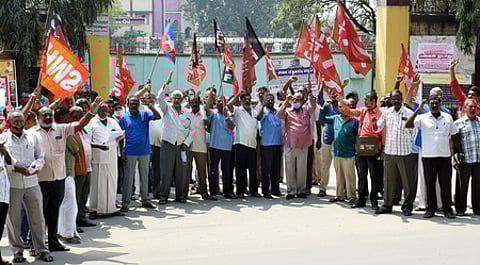 கோவை, சுங்கம் பணிமனை முன்பாக வெள்ளிக்கிழமை ஆா்ப்பாட்டத்தில் ஈடுபட்ட போக்குவரத்து தொழிலாளா்கள்.