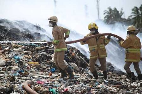 குப்பைக் கிடங்கில் பற்றிய தீயை அணைக்கும் பணியில் ஈடுபட்ட தீயணைப்புப்படை வீரா்கள்.