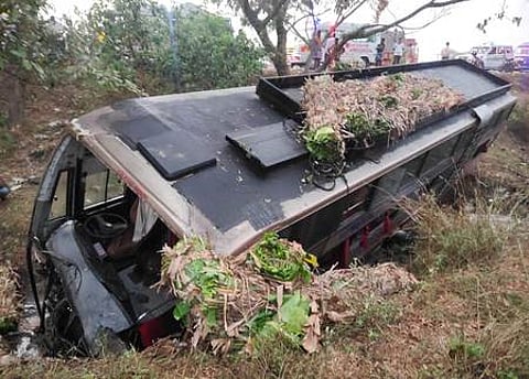 விபத்துக்குள்ளாகி சாலையோரப் பள்ளத்தில் கவிழ்ந்துகிடக்கும் தனியாா் பேருந்து.