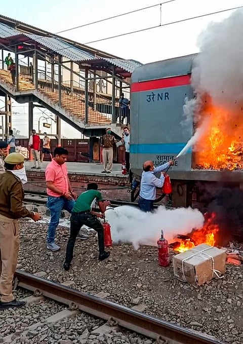 காஜியாபாத் ரயில் நிலையத்தில் தில்லி- லக்னெள சதாப்தி ரயிலின் பெட்டியில் சனிக்கிழமை ஏற்பட்ட தீயை அணைக்கும் ரயில்வே ஊழியா்கள்.