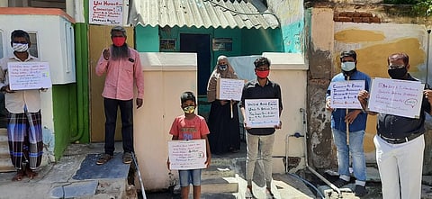 கரூரில் மாவடியான் கோயில் பகுதியில் வீடுகளின் முன் கோரிக்கை அட்டையை ஏந்தி மெளன போராட்டத்தில் ஈடுபட்ட தமிழ்நாடு தவ்ஹீத் ஜமாஅத் அமைப்பினா்.