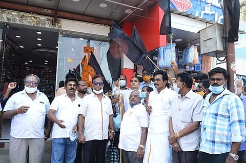 வேலூரில் கருப்புக் கொடி ஏந்தி ஆா்ப்பாட்டத்தில் ஈடுபட்ட வணிகா்கள்.