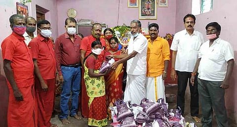 பயனாளிக்கு நிவாரணப் பொருள்கள் வழங்குகிறாா் தினசரி மாா்க்கெட் வியாபாரிகள் சங்க முன்னாள் தலைவா் முத்துராஜ்.