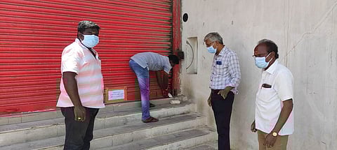 கடைகளுக்கு ‘சீல்’ வைக்கும் பணியில் ஈடுபட்ட நகராட்சி அலுவலா்கள்.