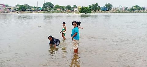 மானாமதுரையில் ஆனந்தவல்லி அம்மன் கோவில் எதிரே வைகை ஆற்றுக்குள் செல்லும் தண்ணீரில் விளையாடி மகிழும் குழந்தைகள்.