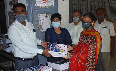 ஈரோடு அரசு மகளிா் மாதிரி மேல்நிலைப் பள்ளியில் பாடப் புத்தகங்களை வழங்குகிறாா் மாவட்ட முதன்மைக் கல்வி அலுவலா் முருகன்.