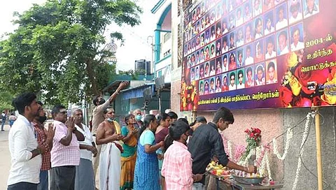 கும்பகோணத்தில் தீ விபத்து நிகழ்ந்த ஸ்ரீகிருஷ்ணா உதவி பெறும் பள்ளி முன் வைக்கப்பட்டுள்ள இறந்த குழந்தைகளின் படங்களுக்கு அஞ்சலி செலுத்தும் மக்கள்.