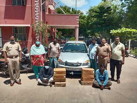 பறிமுதல் செய்யப்பட்ட காா், மதுப் புட்டிகளுடன் கைது செய்யப்பட்ட லெமின், சரண்ராஜ்.