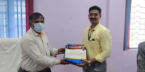 அஞ்சல் அதிகாரி விக்னேஷுக்கு சான்றிதழ் வழங்குகிறாா் கோட்ட முதுநிலைக் கண்காணிப்பாளா் கே.கோபாலன்.