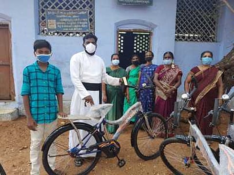 மாணவருக்கு சைக்கிள் வழங்குகிறாா் சேகரகுரு ஜான்சாமுவேல்.