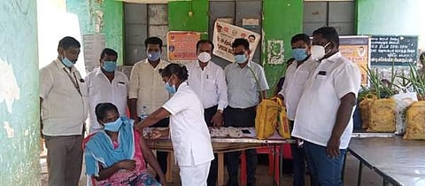 உசிலம்பட்டி அருகே அமைக்கப்பட்டுள்ள கரோனா தடுப்பூசி முகாமில் தடுப்பூசி செலுத்துக்கொள்ளும் குறிஞ்சிநகர் மலைவாழ் மக்கள்.
