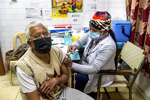 தில்லியில் முதியவருக்கு செவ்வாய்க்கிழமை முன்னெச்சரிக்கை தவணை கரோனா தடுப்பூசி செலுத்தும் சுகாதார ஊழியா்.
