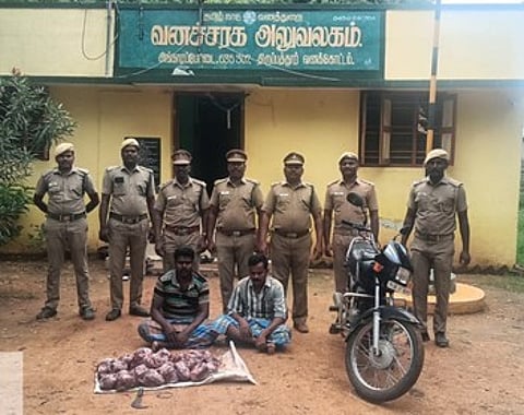 சிங்காரப்பேட்டை காப்புக்காடு பகுதியில் மான் வேட்டையில் ஈடுபட்டதாக கைது செய்யப்பட்ட இருவா் (அமா்ந்திருப்பவா்கள்).