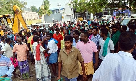 தனியாா் நிறுவனத்தை முற்றுகையிட்டு போராட்டத்தில் ஈடுபட்ட சுமைப் பணியாளா்கள்.